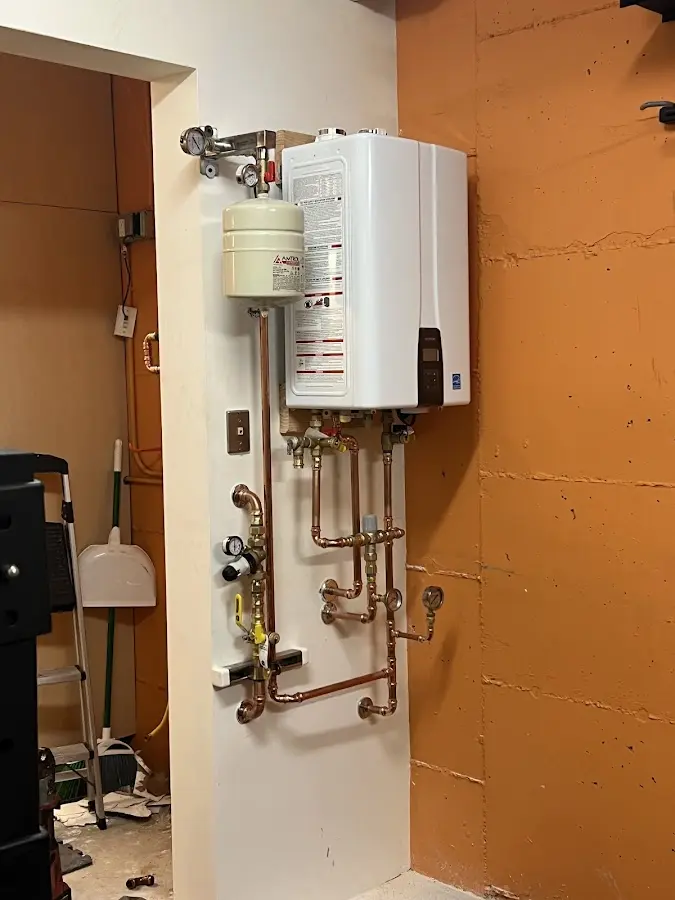 Plumbing technician inspecting water heater connections in Shiprock